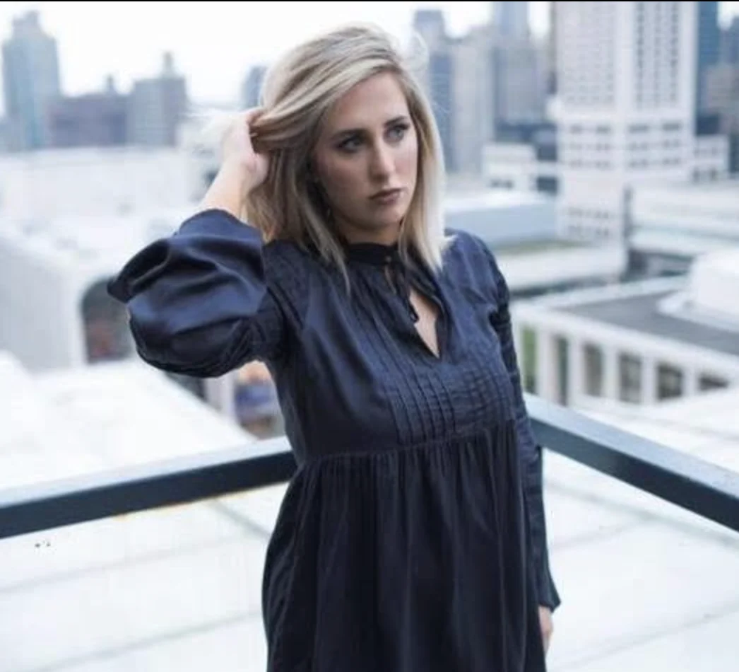 Elizabeth Faye on a city rooftop in a navy dress