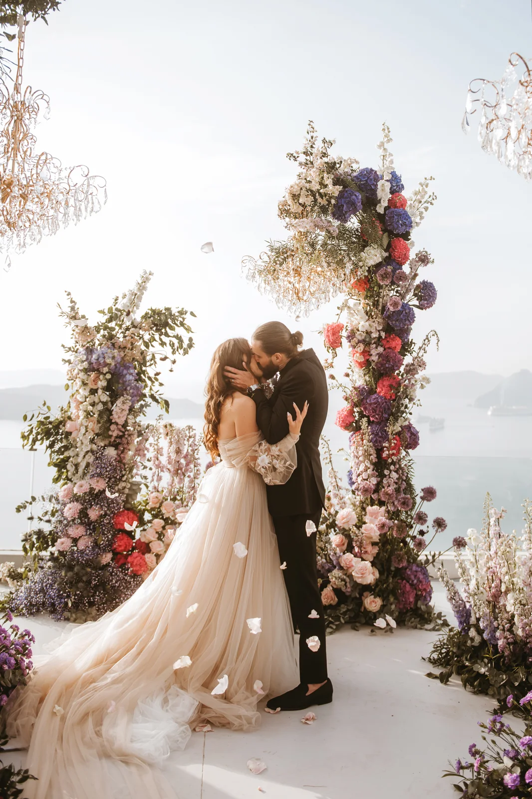 Elizabeth Faye and Derek kissing under a flower arch on their wedding day