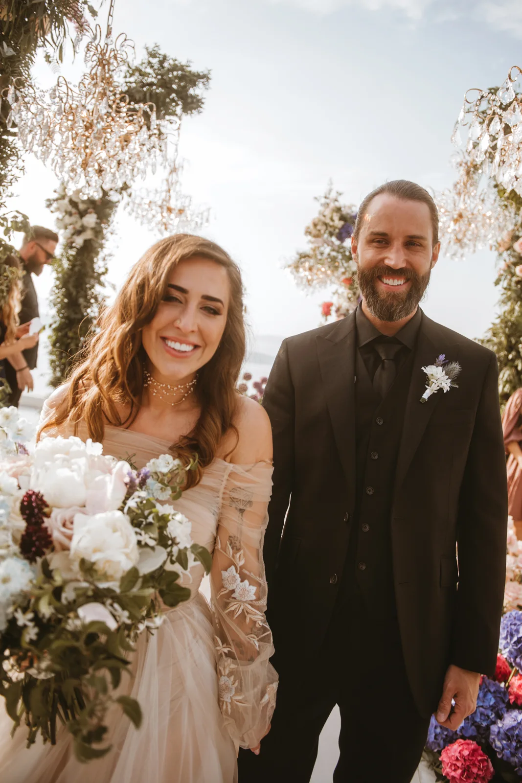 Elizabeth Faye and Derek smiling after the ceremony, bouquet in hand